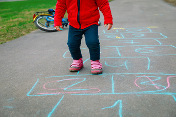 little girl play hopscotch on playground