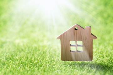 Model of wooden house on green grass background