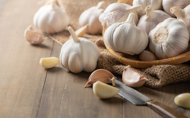 Garlic on bamboo basket on wood background
