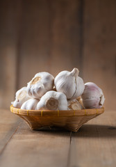 Garlic on bamboo basket on wood
