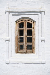 Old brown wooden window on white ancient historical house wall.