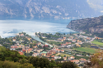 Fototapeta na wymiar Panorama of Lake Garda, lakeside village Torbole and mountains, Italy