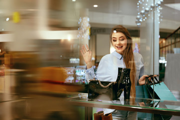 Young Woman Looking Through Shop Window