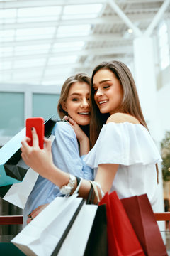 Shopping. Smiling Women Taking Photos In Shopping Centre