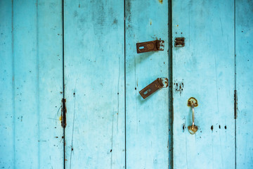 Vintage distressed blue wooden door with latches.