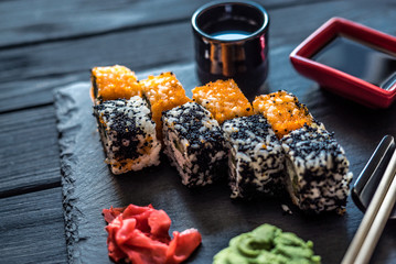 sushi and dishes for sushi on a black table