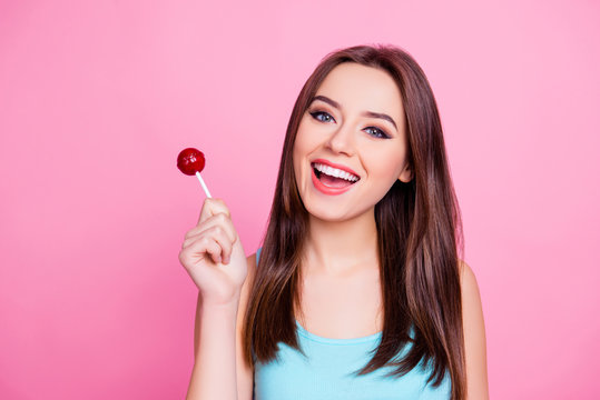 Portrait of cute tender gentle sweet attractive having fun carefree amazing woman wearing blue singlet holding red candy, isolated on vivid pink background