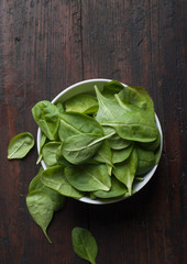 spinach leaves on a dark wood background
