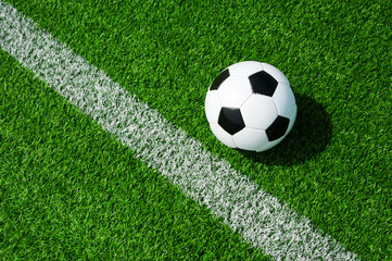 Fussball Ball neben der Markierung Linie auf grünem Kunstrasen am Feld