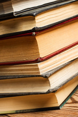 Libros apilados sobre una mesa de madera rústica. Vista de frente y de cerca