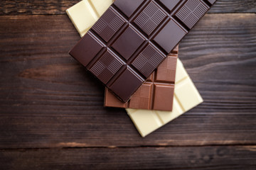 Delicious chocolate bars on wooden background