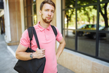 portrait of handsome young man with beard in town returning