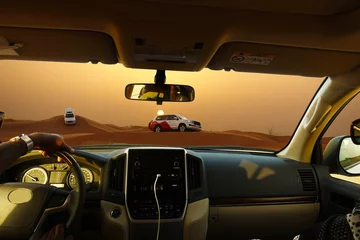 Foto op Plexiglas Off road safari with SUV vehicles in the desert at sunset, view from the car   © adrian_ilie825
