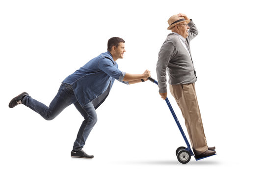 Young man pushing a hand truck with a mature man riding on it