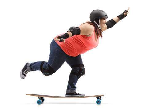 Overweight woman wearing protective gear riding a longboard