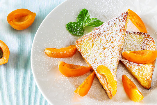 French toasts with fresh cut apricot, mint and icing powder. Healthy classic breakfast concept. Top view. Close up.