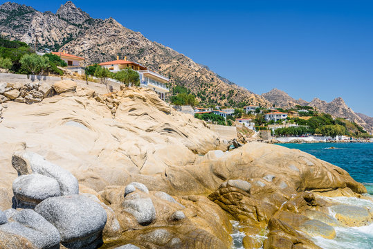 Ikaria Island, Karkinagri, Sporades, Greece: Beautiful sunny greek village town orthodox greek church and harbor view to the blue sea with crystal clear water and fishing boats cruising yacht at shore