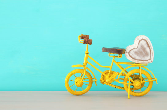 Image of metal yellow bicycle with heart, present for dad. Father's day concept.