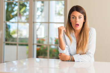 Fototapeta premium Young beautiful woman at home scared in shock, expressing panic and fear
