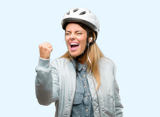 Young woman with bike helmet and earphones irritated and angry expressing negative emotion, annoyed with someone