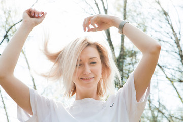 Fototapeta premium Portrait of smilling blonde young girl in the forest close-up