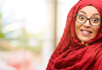 Young arab woman wearing hijab confident and happy with a big crazy smile laughing