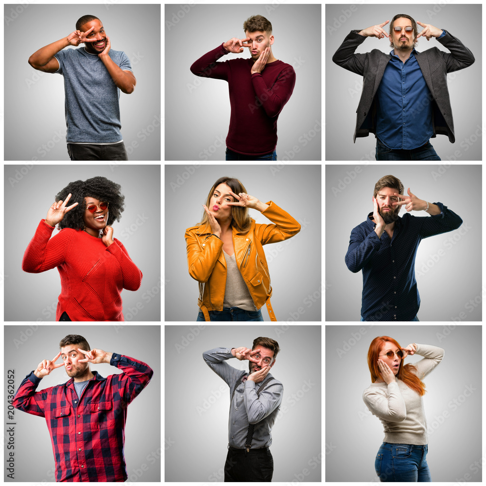 Wall mural Group of mixed people, women and men looking at camera through fingers in victory gesture winking the eye and blowing a kiss