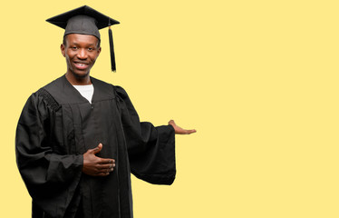 Young african graduate student black man confident and happy with a big natural smile inviting to...