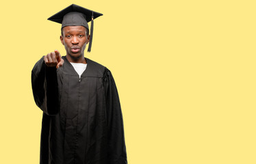 Young african graduate student black man pointing to the front with finger
