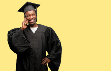 Young african graduate student black man happy talking using a smartphone mobile phone