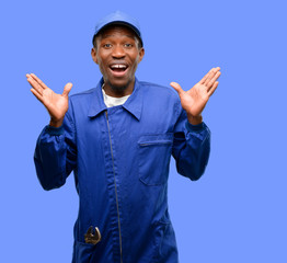 Naklejka premium African black plumber man happy and surprised cheering expressing wow gesture