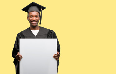 Young african graduate student black man holding blank advertising banner, good poster for ad,...