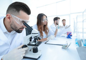 Fototapeta premium male laboratory technician looking at samples in the microscope