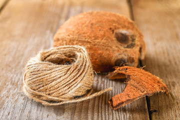 Rope of fiber coir and coconut shell on an old wooden table.