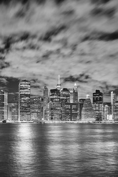 Black and white picture of Manhattan skyline illuminated at night, New York City, USA.
