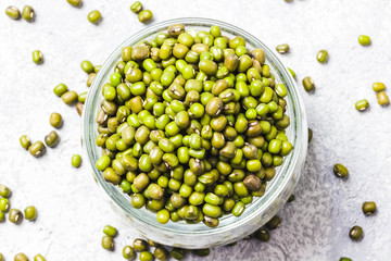 Mung beans in glass jar on concrete background. Top view, space for text.