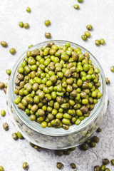 Mung beans in glass jar on concrete background. Top view, space for text.