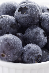 Closeup of juicy blueberries with water drops, in a bowl, healthy eating concept