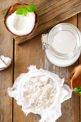 Squeezing milk from the chips of coconut in the gauze on an old wooden table.