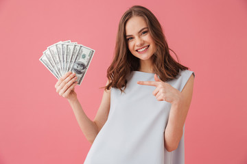 Smiling young woman showing money pointing.