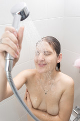 Closeup portrait of young brunette woman washing in shower
