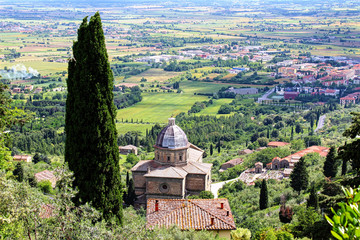 Cortona, Italy. Panoramic view of the tuscany countryside with cypres and the church of Santa Maria delle Grazie al Calcinaio.