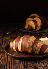 French croissants on a wooden background. Breakfast with tea and coffee.