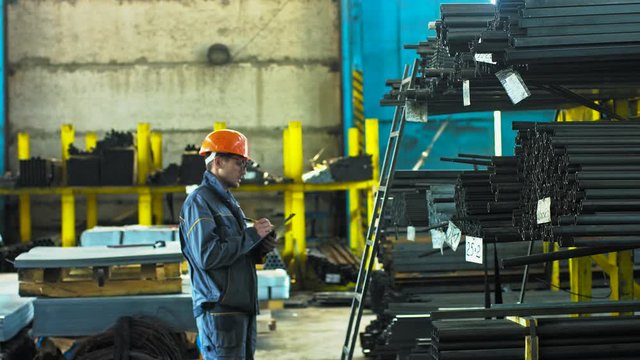 Mature male warehouse manager checking stocks with a clipboard