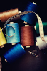 Pile of colorful spools of thread and measuring meter 