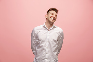 Obraz premium The happy business man standing and smiling against pink background.