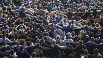 Happy football soccer fans hugging, dancing in joy at stadium, celebrating goal. Excited crowd jumping, celebrating victory, 4K - Powered by Adobe