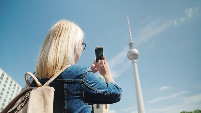 A woman takes photos of the Berlin TV tower. Journey through Berlin and Europe concept