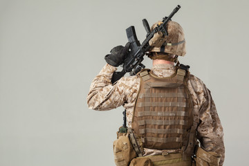 Soldier in camouflage holding rifle
