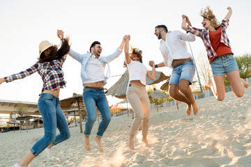 Group of happy friends partying on beach